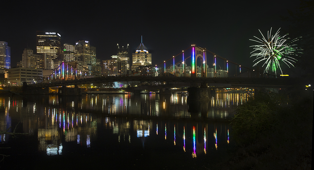 Rachel Carson Bridge shines with colorful Energy Flow lights as fireworks explode.